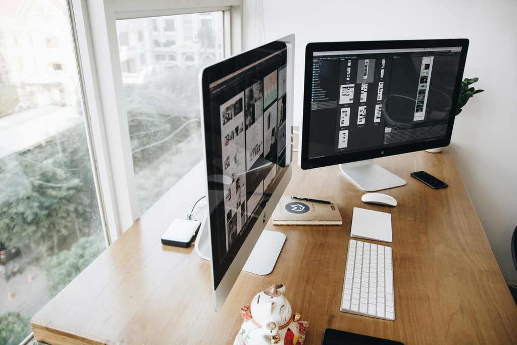 Uspořádaný pracovní stůl s počítačem a dvěma obrazovkami – profesionální webdesign
